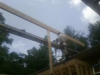 Carpenter setting a ridge beam over a new addition frame — Ice Dam Removal by Roofing Brothers in Saint Ansgar