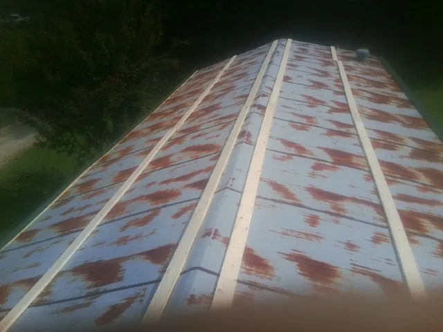 Rusted metal roof panels with new wood purlins before replacement — Storm Damage Roof Repair in Saint Ansgar by Roofing Brothers