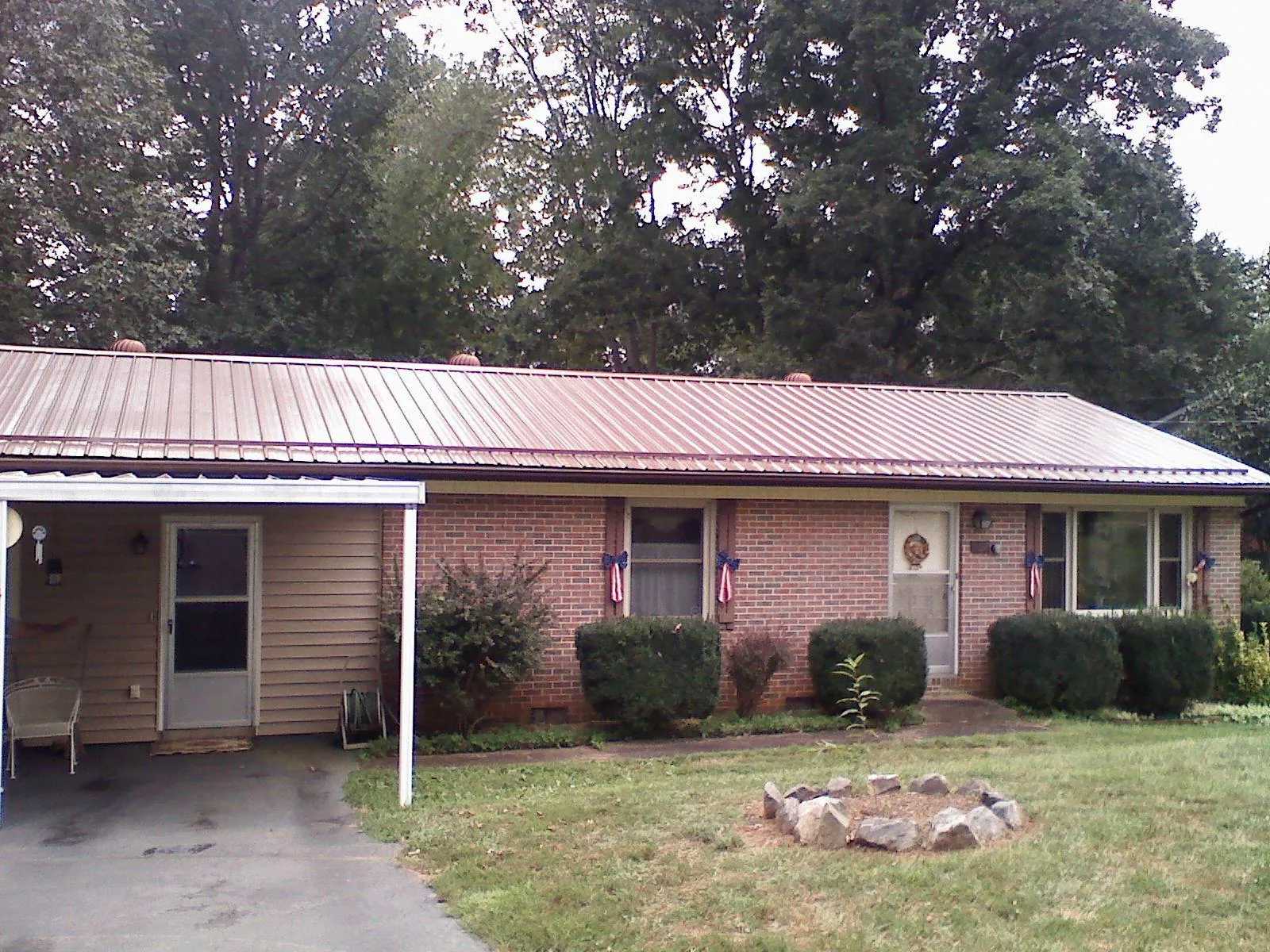 Bronze metal roof and carport on a brick ranch home — Roof Repair work by our crew in Saint Ansgar